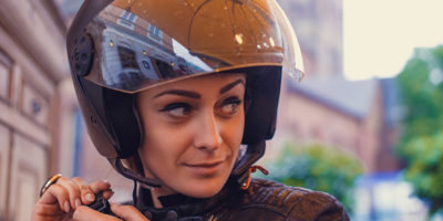 Kobieta zapina kask motocyklowy z interkomem